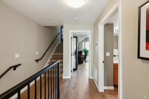a view of a hallway with wooden floor and stairs
