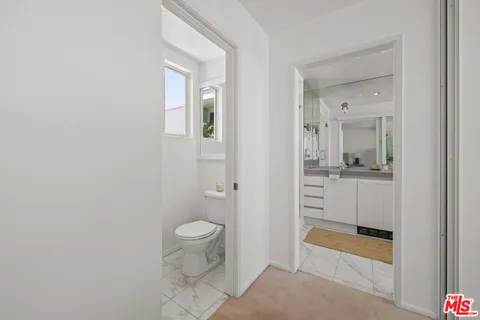 a bathroom with a granite countertop sink mirror and toilet