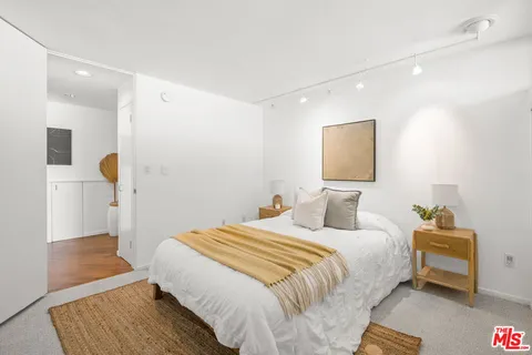 a bedroom with a bed and a night stand