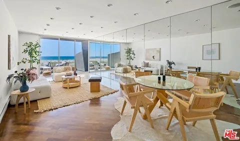 a kitchen with stainless steel appliances kitchen island granite countertop a table chairs sink and cabinets