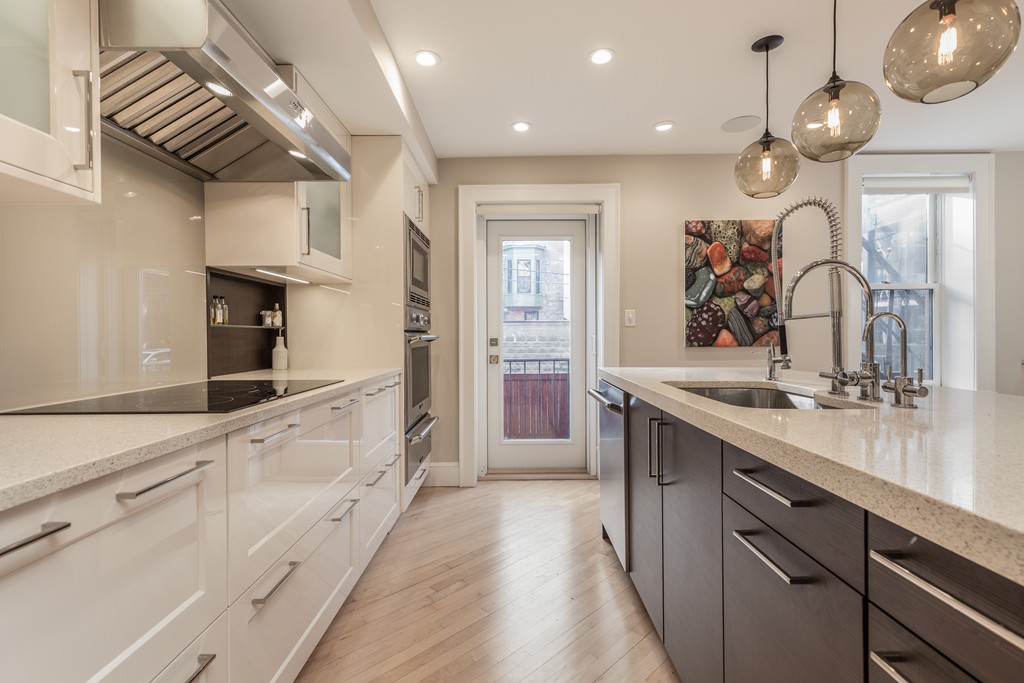 50 Rutland Square, Unit 1 Boston, MA 02118 - Photo 2 of 12 a large kitchen with granite countertop a large kitchen island white cabinets and wooden floor