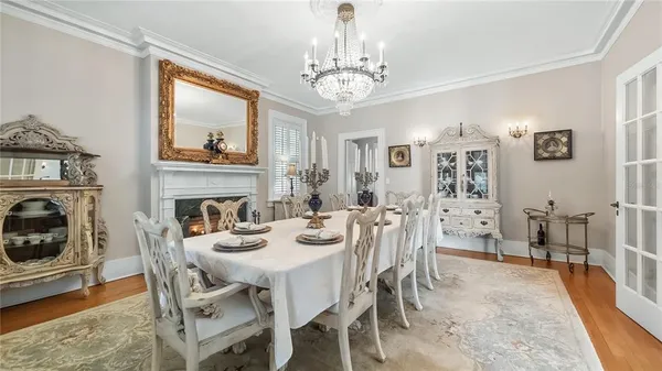 a view of a dining room with furniture a chandelier and wooden floor