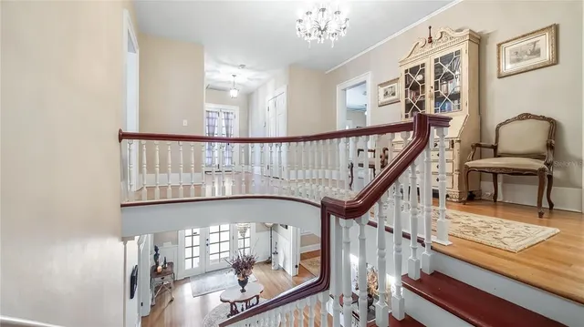 a view of an entryway wooden floor and chandelier