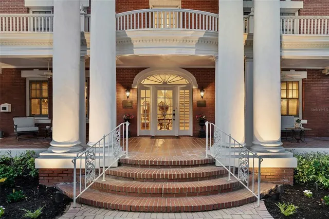 a front view of a house with a floor to ceiling window and potted plants