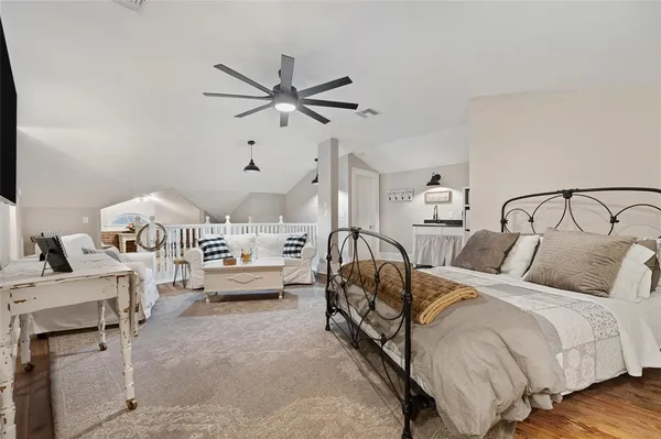a spacious bedroom with a bed a couch and a chandelier
