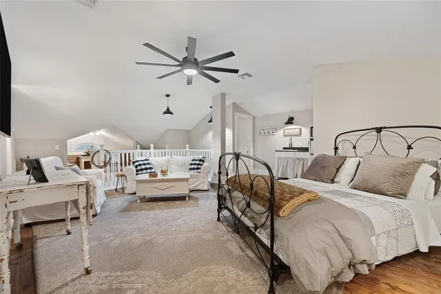 a spacious bedroom with a bed a couch and a chandelier