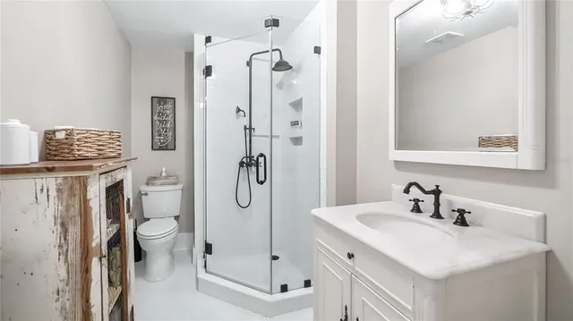 a bathroom with a sink vanity mirror and toilet
