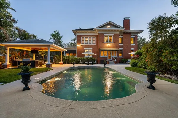 a view of a house with swimming pool and sitting area