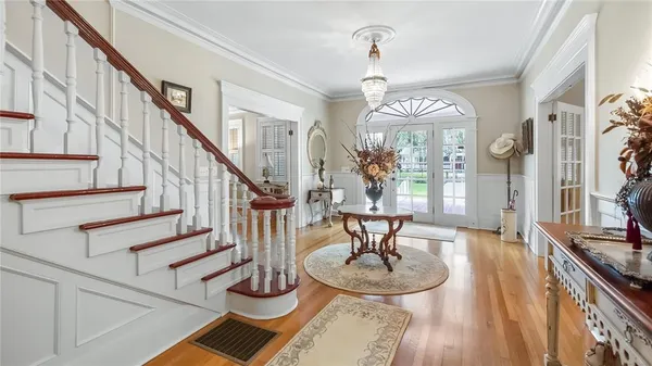 a view of a dining room with furniture a chandelier and wooden floor