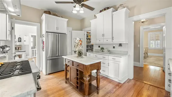 a kitchen with a refrigerator a sink cabinets and wooden floor