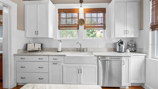 a kitchen with granite countertop white cabinets and a window