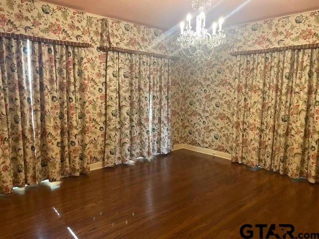a view of a livingroom with wooden floor a fireplace and windows