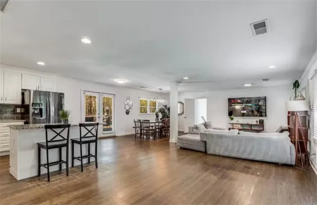 a dining room with furniture a chandelier and wooden floor