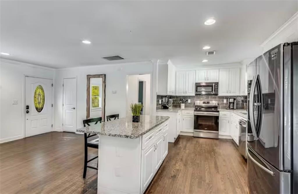 4050 Washington Road East Point, GA 30344 - Photo 28 of 58 a kitchen with white cabinets and stainless steel appliances