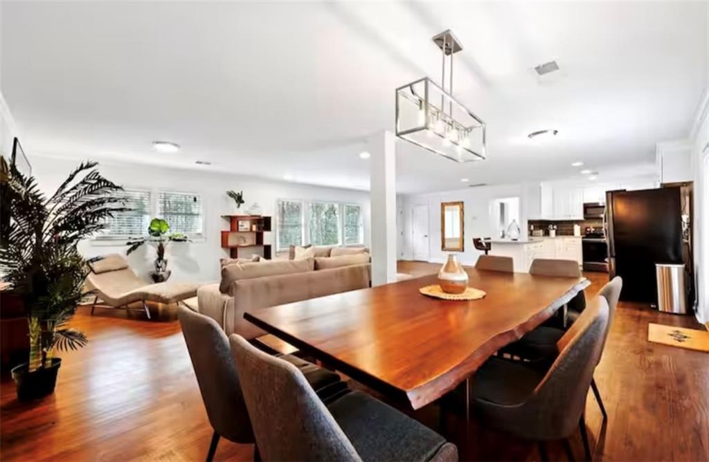 4050 Washington Road East Point, GA 30344 - Photo 3 of 58 a view of a dining room and livingroom with furniture wooden floor a chandelier