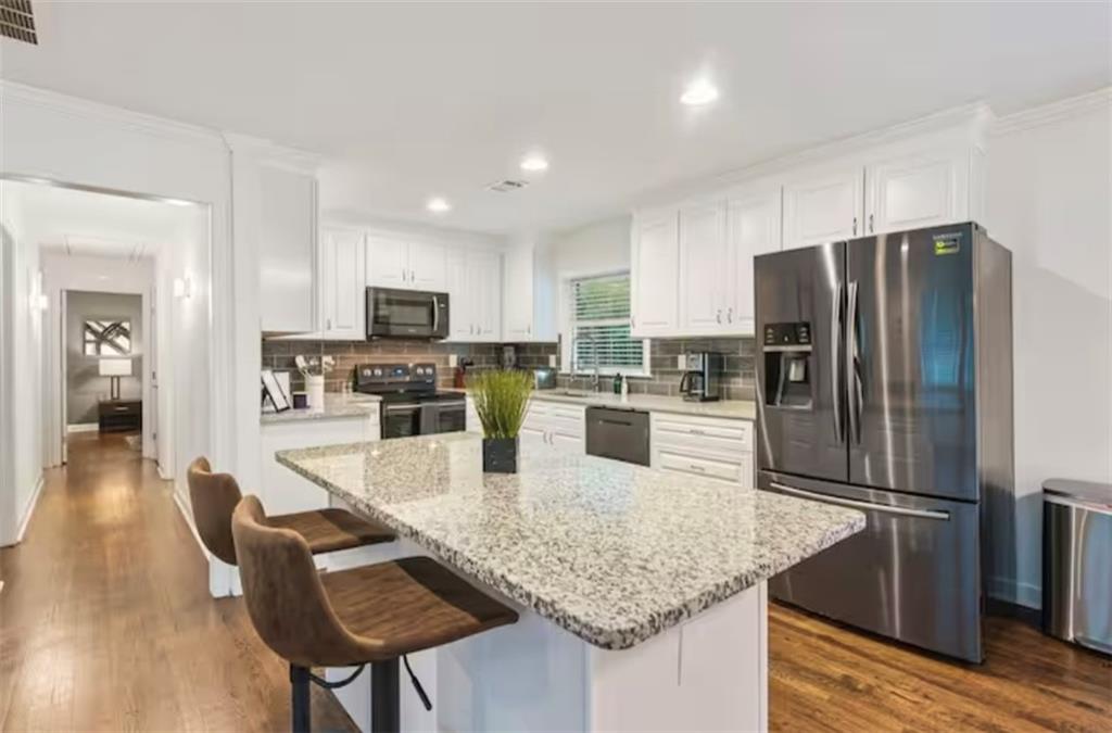 4050 Washington Road East Point, GA 30344 - Photo 32 of 58 a kitchen with granite countertop stainless steel appliances a refrigerator a stove a sink a dining table and chairs