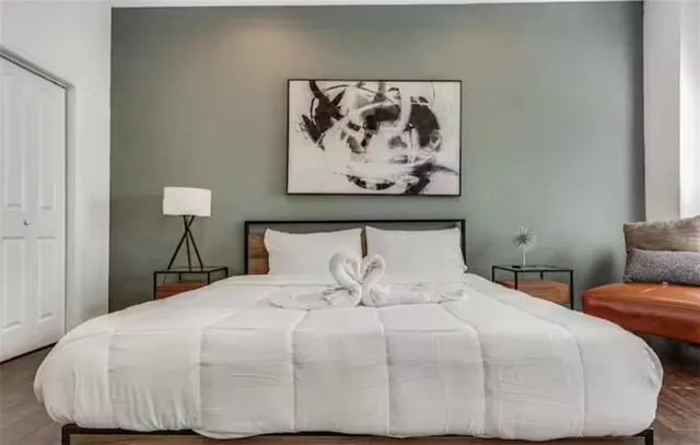 a bedroom with a bed and a flat tv screen on the dresser