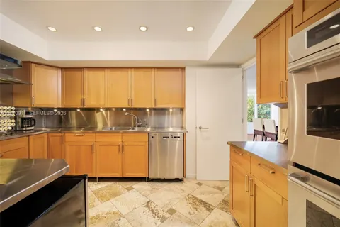 a kitchen with stainless steel appliances granite countertop a sink and a refrigerator