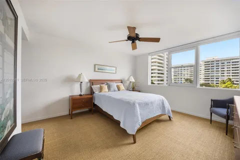 a bedroom with a bed a chair and a large window