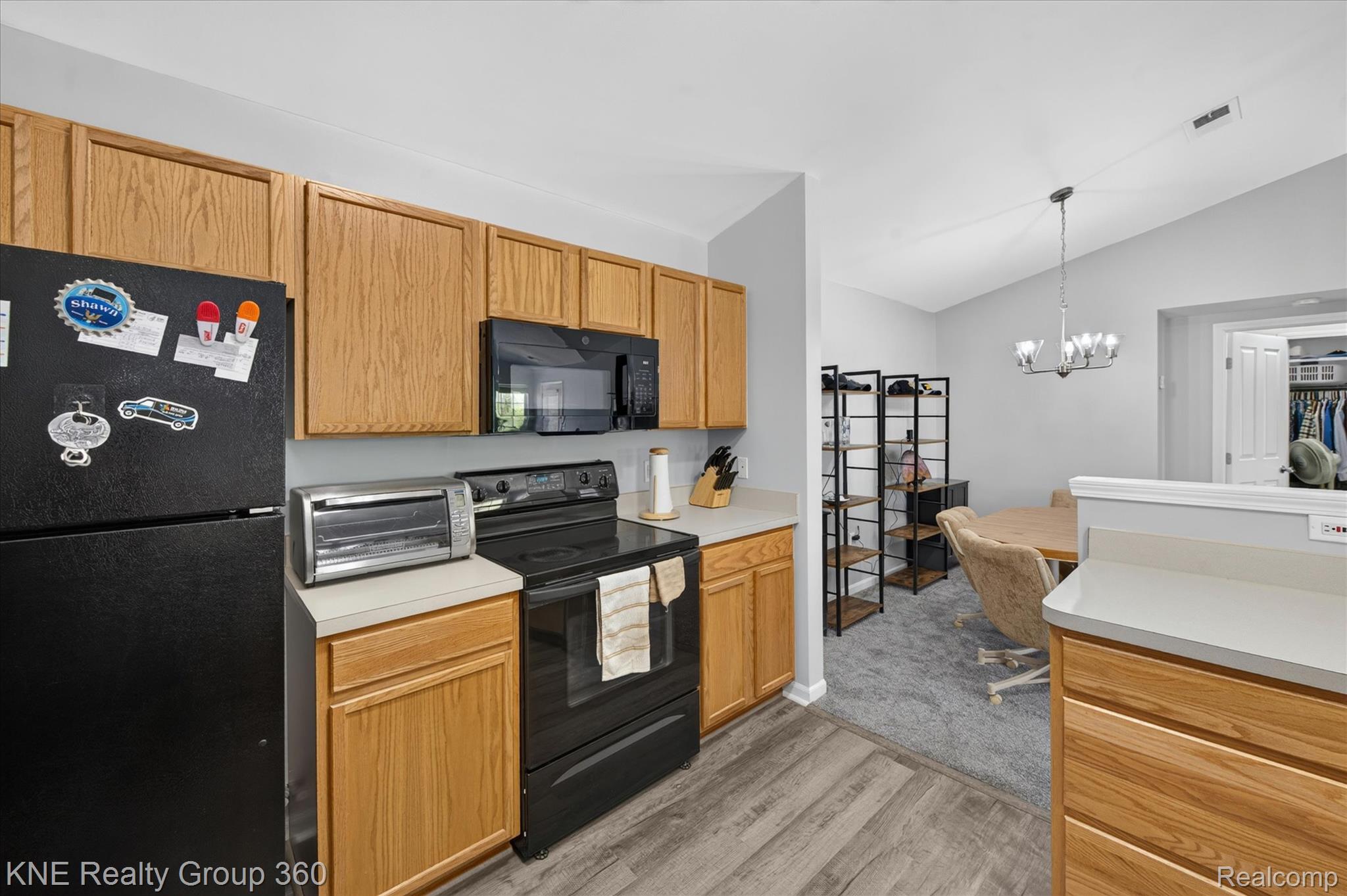 4077 Berkeley Avenue Canton, MI 48188 - Photo 14 of 32 Kitchen featuring wood-finish cabinetry, black appliances, light-toned countertops, and wood-look flooring