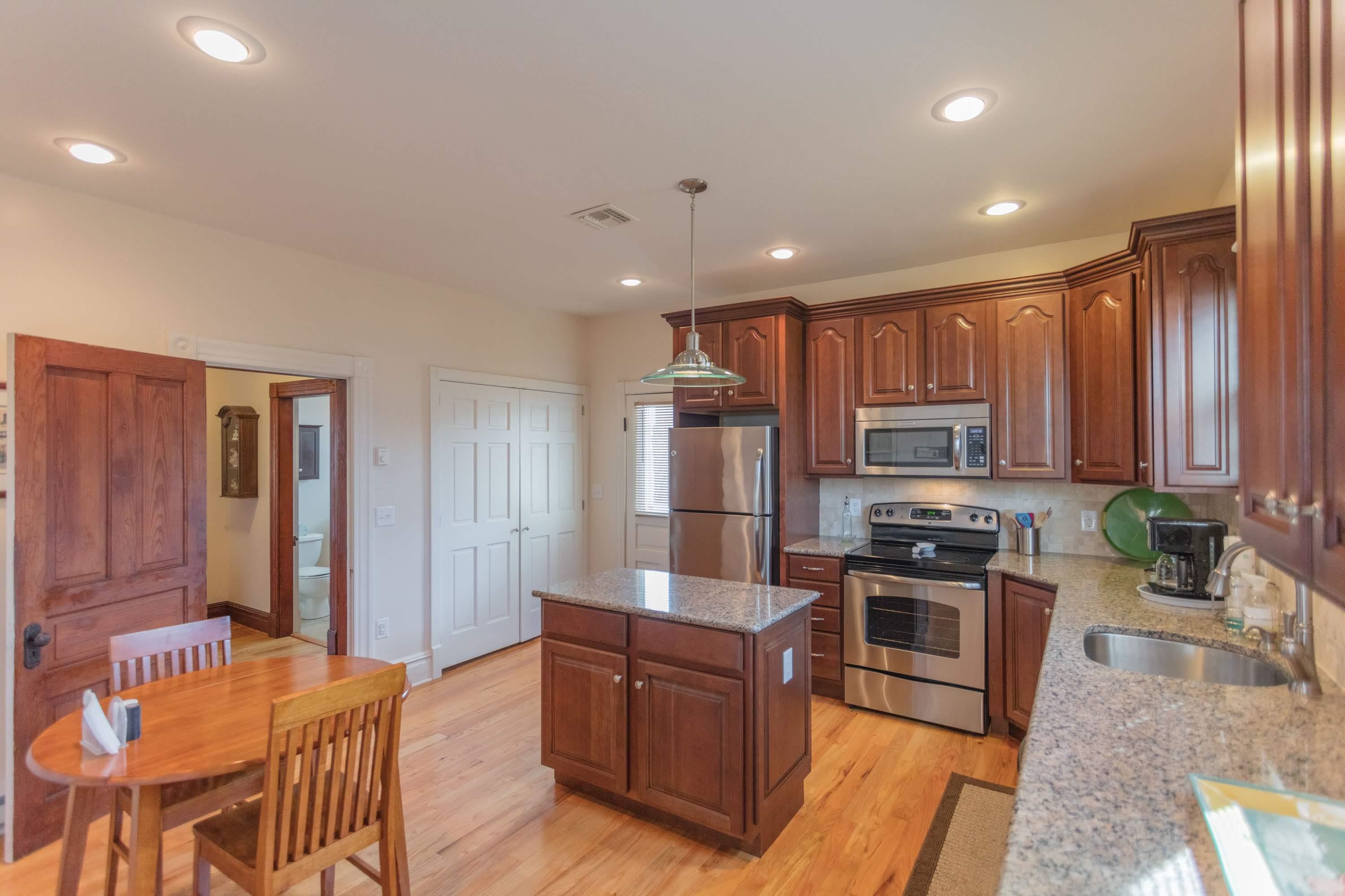 11 Shady Lane Raphine, VA 24472 - Photo 23 of 41 a kitchen with stainless steel appliances granite countertop a stove top oven a sink dishwasher a dining table and chairs with wooden floor