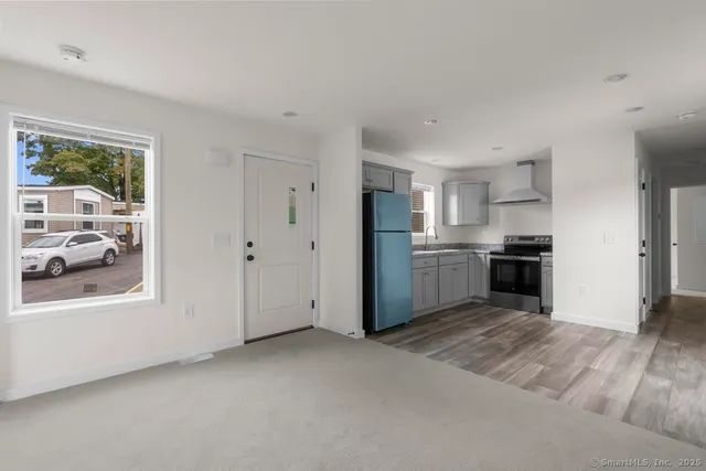 a view of a kitchen with a sink a refrigerator and window