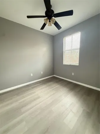 an empty room with a window and a fan