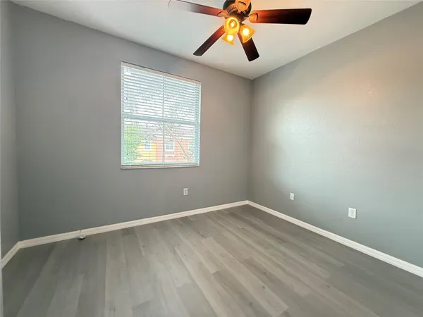 an empty room with a window and a fan