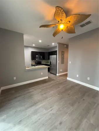 a view of a kitchen with a chandelier fan and wooden floor