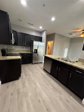 a kitchen with stainless steel appliances kitchen island granite countertop a sink counter space and cabinets
