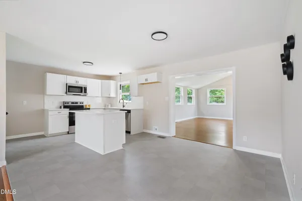 a view of kitchen with sink and white cabinets