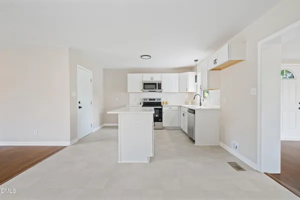 a kitchen with white cabinets and white appliances