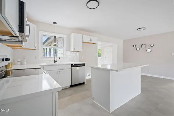 a kitchen with white cabinets and sink