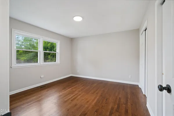 a view of a room with wooden floor and window