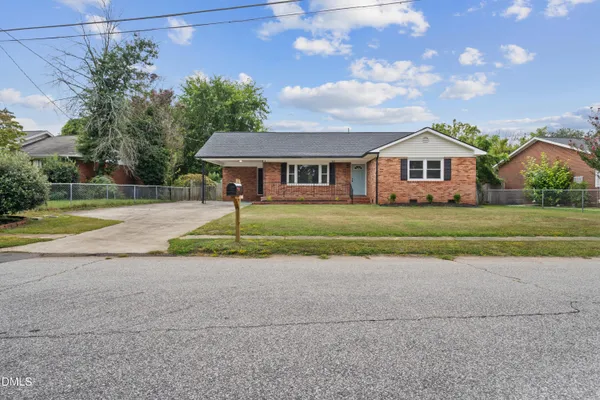 a front view of a house with a yard and trees