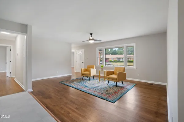 a living room with dining table and a large window