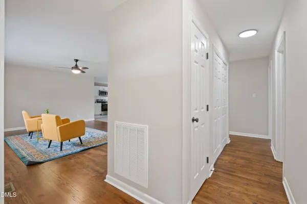 a view of a hallway with wooden floor and furniture