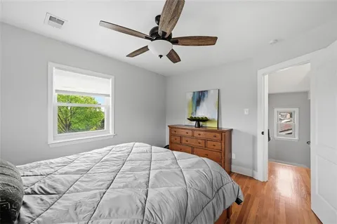a bedroom with a bed and wooden floor