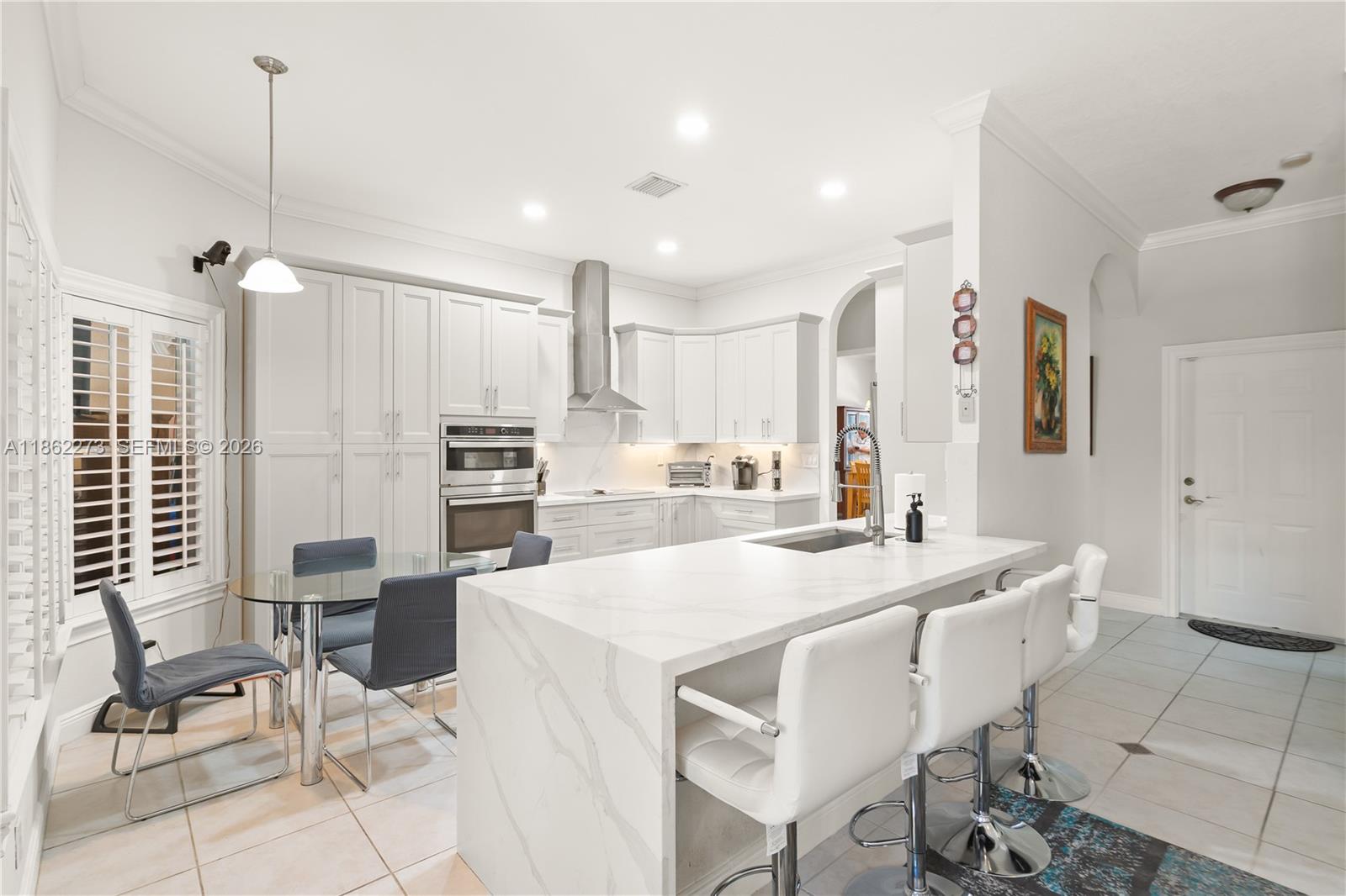 8366 Southwest 193rd Street Cutler Bay, FL 33157 - Photo 7 of 20 a large kitchen with kitchen island a large counter top space appliances and cabinets
