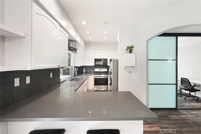 a kitchen with stainless steel appliances a refrigerator a stove a microwave a sink and a refrigerator