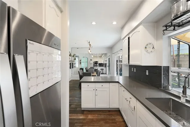 a kitchen with granite countertop a sink stainless steel appliances and cabinets