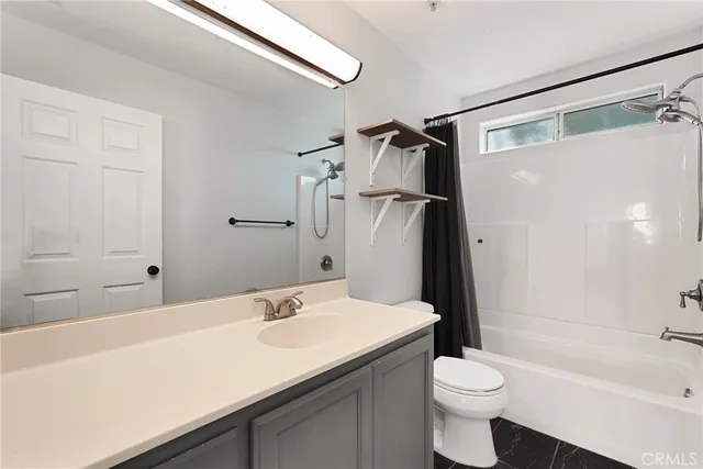 a bathroom with a sink a toilet a mirror and shower