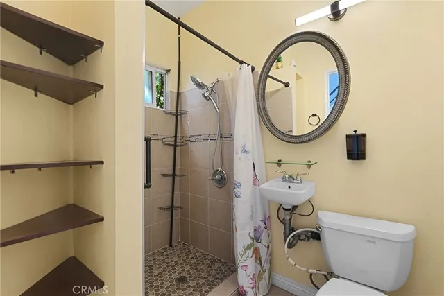 a bathroom with a sink a toilet and a mirror