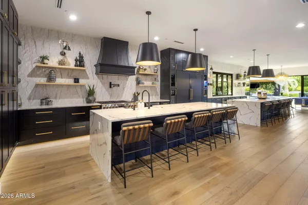 a kitchen with stainless steel appliances kitchen island granite countertop a table chairs sink and cabinets