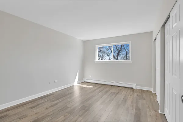 an empty room with a window and wooden floor