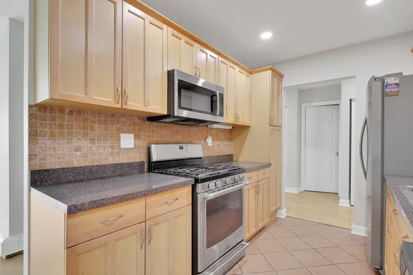 a kitchen with stainless steel appliances granite countertop a stove a refrigerator and a microwave