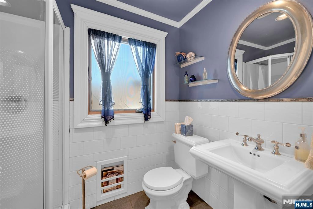 285 Chestnut Ridge Road Woodcliff Lake, NJ 07677 - Photo 20 of 46 a bathroom with a toilet a sink and mirror