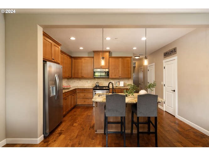 4307 Northwest Sage Loop Camas, WA 98607 - Photo 16 of 40 a kitchen with refrigerator a sink and chairs