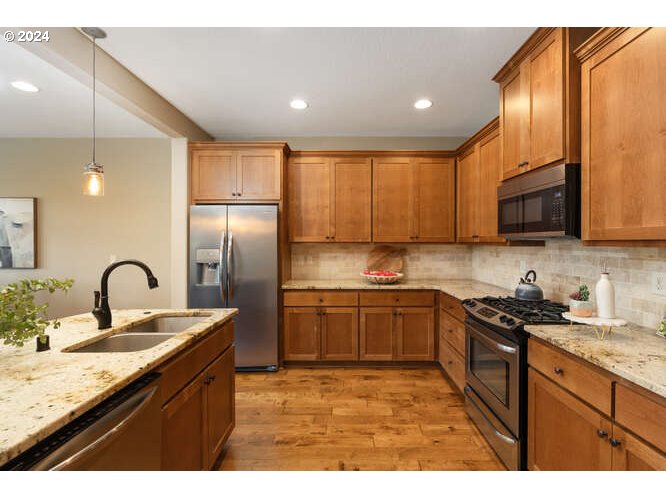 4307 Northwest Sage Loop Camas, WA 98607 - Photo 19 of 40 a kitchen with stainless steel appliances granite countertop a sink stove and refrigerator