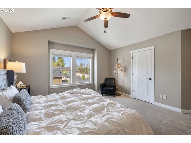4307 Northwest Sage Loop Camas, WA 98607 - Photo 24 of 40 a bedroom with a large bed and a chandelier